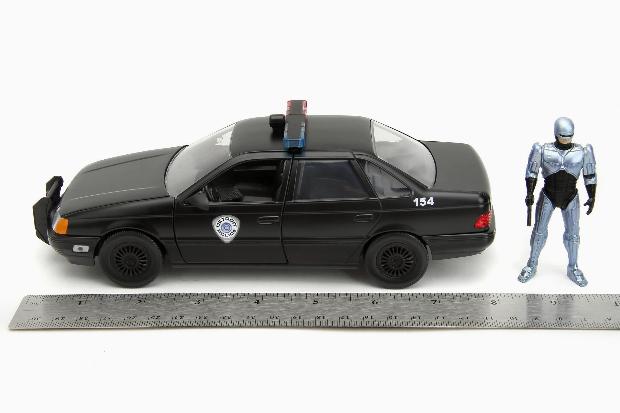 Jada - Robocop 1986 Ford Taurus, 253225060, +8 anni, in metallo pressofuso, in scala 1:24, parti apribili, sistema a ruota libera, personaggio incluso